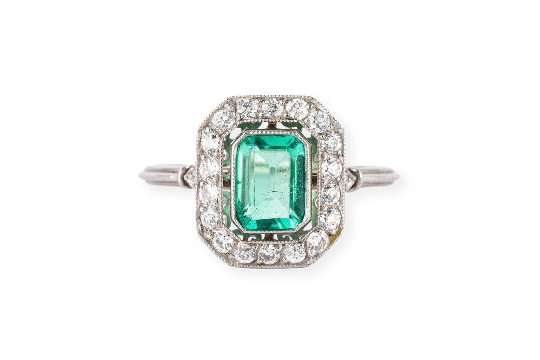 FEINER SMARAGD ENTOURAGE RING: FEINER SMARAGD ENTOURAGE RING PT 950. Ringmass: ca. 54. Ringkopfmasse: ca. 12,6 x 10,9 mm. Ges.-Gew.: ca. 3,2 g. Ring, besetzt mit einem zentralen Smaragd von ca. 0.67 ct. und einem Kranz aus Diamante