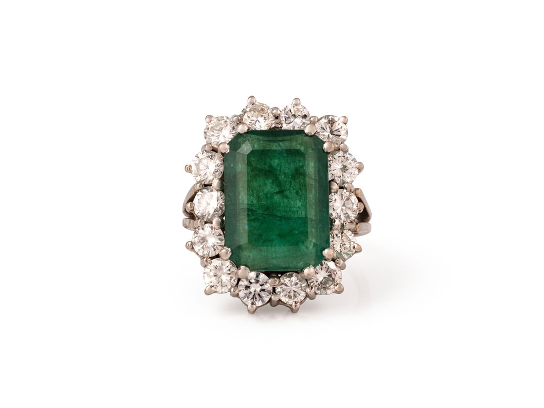 SMARAGD COCKTAIL RING: SMARAGD COCKTAIL RING WG 750 (getestet). Ringmass: ca. 49. Ges.-Gew.: ca. 10,3 g. Ring, besetzt mit einem zentralen Smaragd von ca. 5.50-6.00 ct. und einem Kranz aus Diamanten zus. ca. 1.40 ct. H/VVS-
