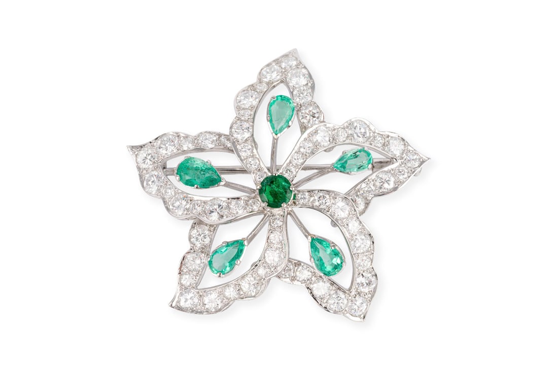 FLORALE SMARAGD BROSCHE: FLORALE SMARAGD BROSCHE WG 585. Masse: ca. 39,5 x 35,2 mm. Ges.-Gew.: ca. 8,1 g. Bosche im Bluetenmotiv, besetzt mit Smaragden und reichlich Brillanten zus. ca. 1.50 ct. F-H/VVS-P.