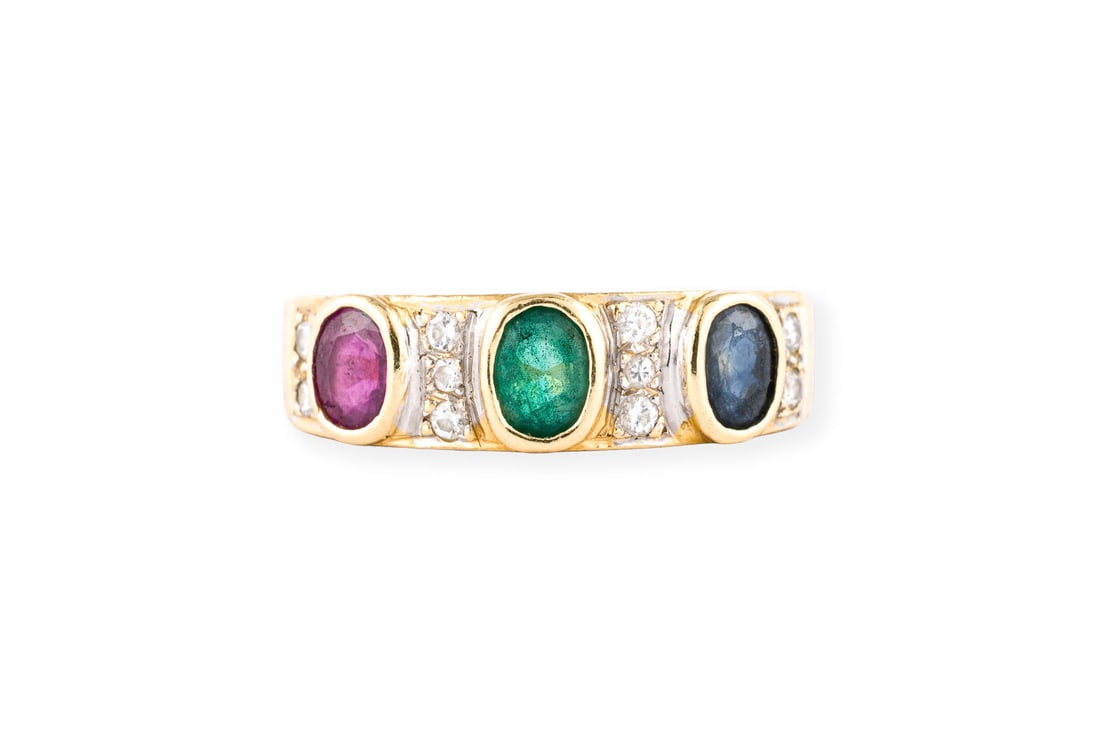 TUTTI FRUTTI BANDRING: TUTTI FRUTTI BANDRING GG 750. Ringmass: ca. 55. Ringbreite: ca. 5,9 mm. Ges.-Gew.: ca. 4,5 g. Ring, besetzt mit je einem Saphir, Smaragd und Rubin, sowie kleinen Brillanten.