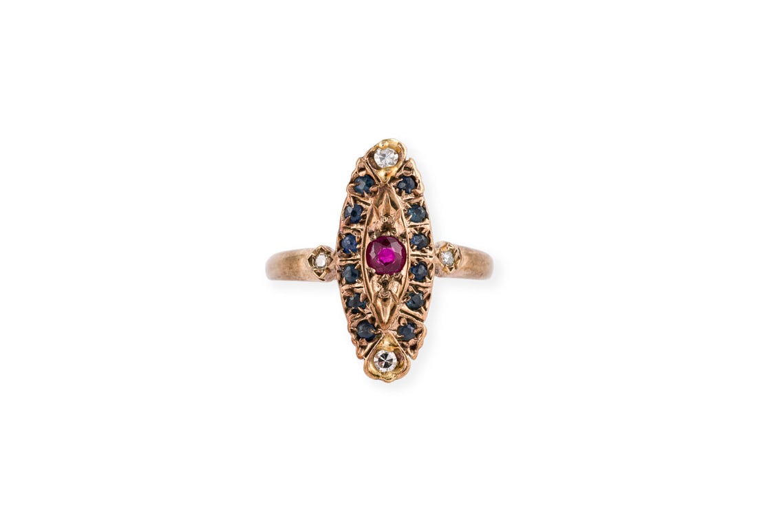 NAVETTEFOERMIGER RING: NAVETTEFOERMIGER RING RG 585. Ringmass: ca. 53. Ringkopfmasse: ca. 19,1 x 8,3 mm. Ges.-Gew.: ca. 2,4 g. Navettefoermiger Ring, besetzt mit einem zentralen, kleinen Rubin, Saphiren und vier Diamanten