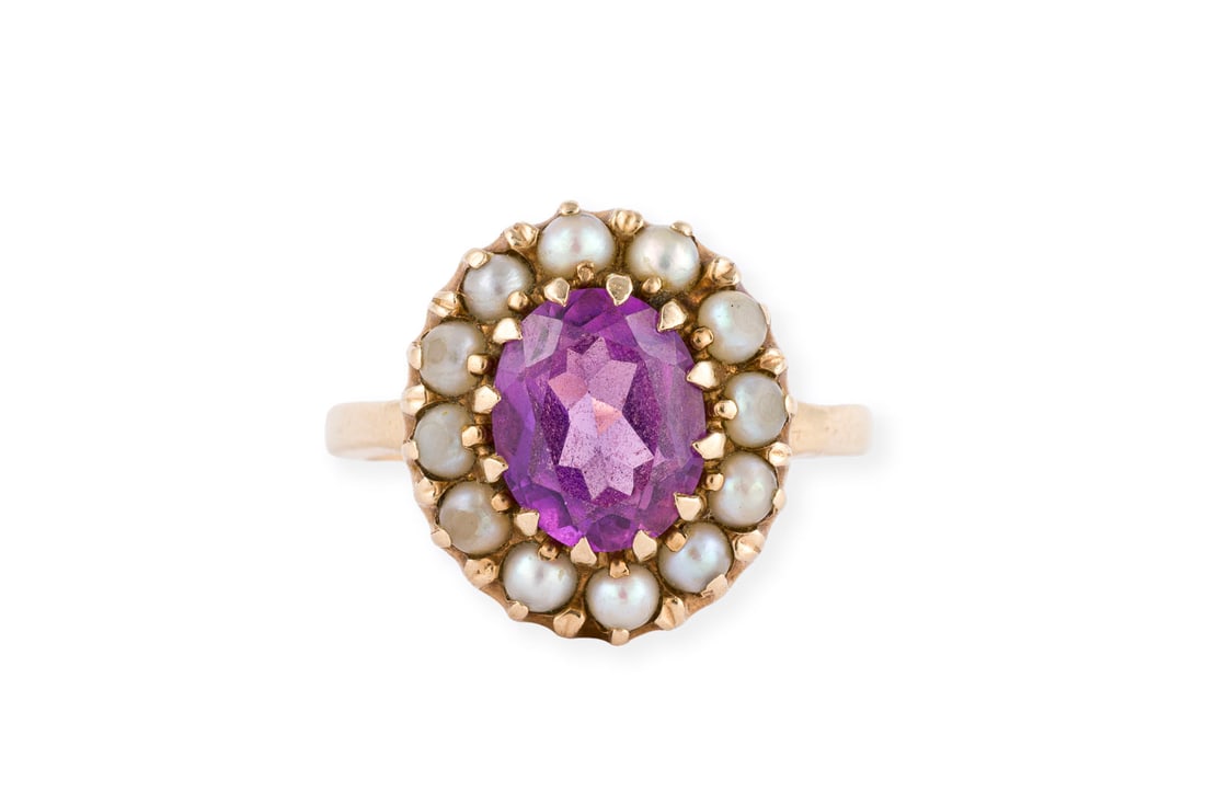 PERLEN COCKTAIL RING: PERLEN COCKTAIL RING GG 585 (getestet). Ringmass: ca. 17,0 x 15,0 mm. Ges.-Gew.: ca. 6,1 g. Ring, besetzt mit einem zentralen lila Farbstein - wohl synthetischer Saphir - und einem Kranz aus Perlen.