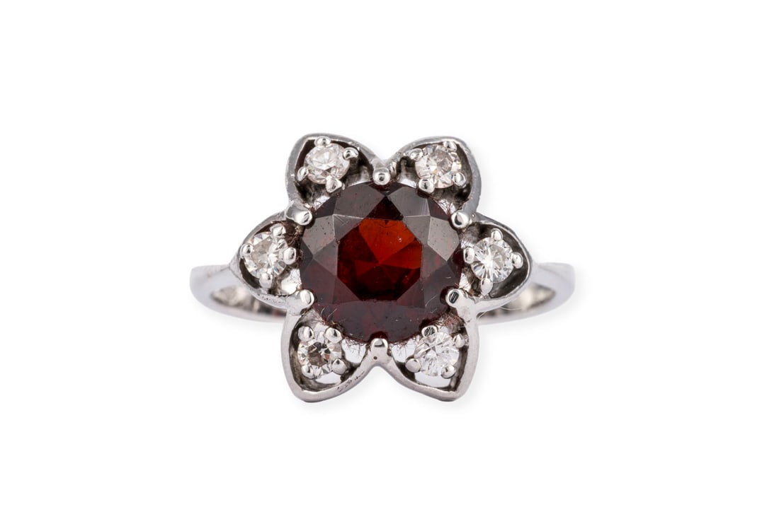 GRANAT BLUETEN RING: GRANAT BLUETEN RING WG 585. Ringmass: ca. 53. D.(Ringkopf): ca. 15,3 mm. Ges.-Gew.: ca. 5,3 g. Ring, besetzt mit einem zentralen Granat von ca. 2.00 ct. und einem Kranz aus Diamanten zus. ca. 0.30