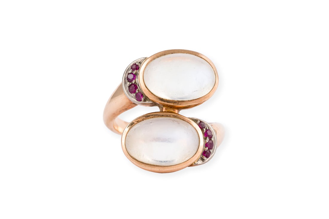 MONDSTEIN RING: MONDSTEIN RING GG 585. Ringmass: ca. 53. Ringkopfmasse: ca. 20,8 x 15,9 mm. Ges.-Gew.: ca. 9,3 g. Ring, besetzt mit zwei Mondstein-Cabochons zus. ca. 8.00 ct. und kleinen Rubinen.