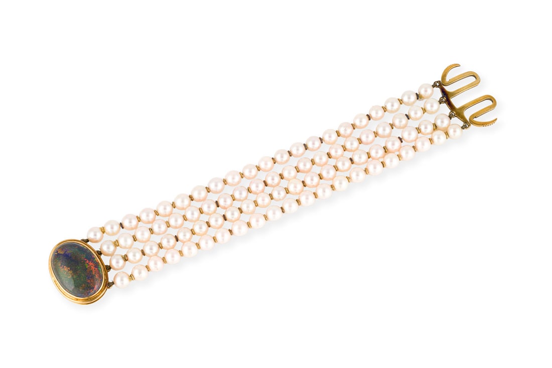 LUXURIOESES OPAL PERLEN ARMBAND: LUXURIOESES OPAL PERLEN ARMBAND GG 585/750. L.: ca. 18,5 cm. B.: ca. 29,8 mm. Ges.-Gew.: ca. 60,8 g. 4-Straengiges Perlenarmband mit goldenen Zwischenringen und einem grossen Opal-Verschluss.
