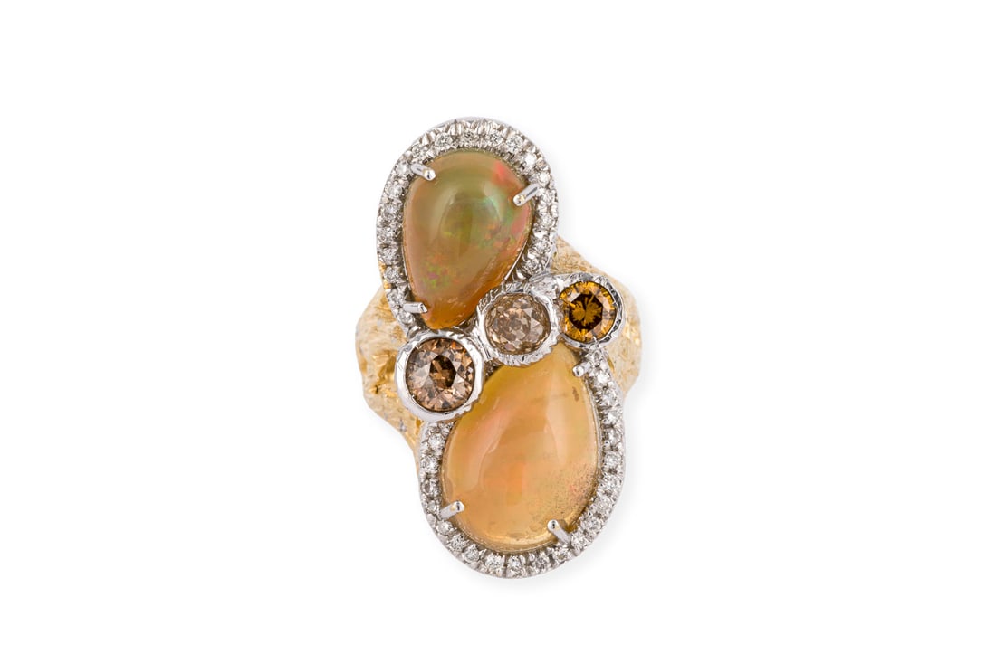 'CODE CASA' DESIGN OPAL RING: CODE CASA' DESIGN OPAL RING WG/GG 750. Ringmass: ca. 60. Ringkopfmasse: ca. 33,6 x 17,8 mm. Ges.-Gew.: ca. 16,0 g. Design Ring, besetzt mit zwei grossen Opal-Cabochons, jeweils mit einem Kranz aus
