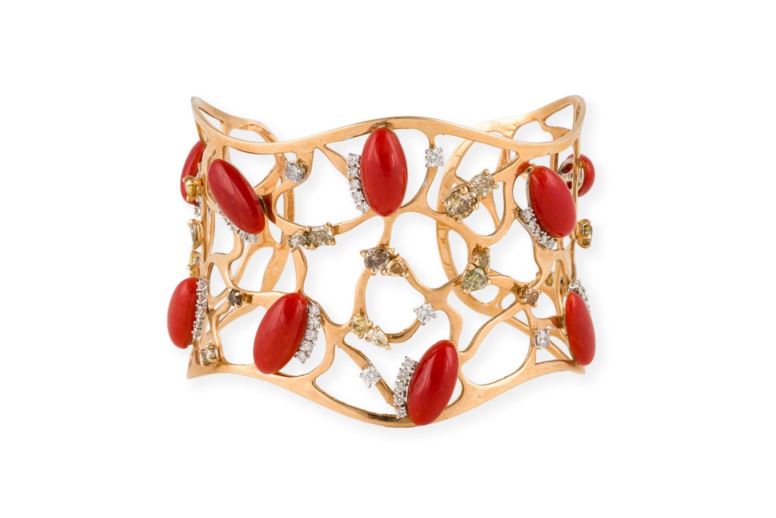 KORALLEN ARMSPANGE Bitte beachten Sie, dass aufgrund der aktuellen Cites-Bestimmungen fuer Objekte: KORALLEN ARMSPANGE GG 750. Ges.-Gew.: ca. 38,6 g. Moderne Armspange aus Mittelmeer-Korallen-Cabochons mit Details aus Brillanten, zus. ca. 1.25 ct., und Fancy Brillanten zus. ca. 3.33 ct. Bitte