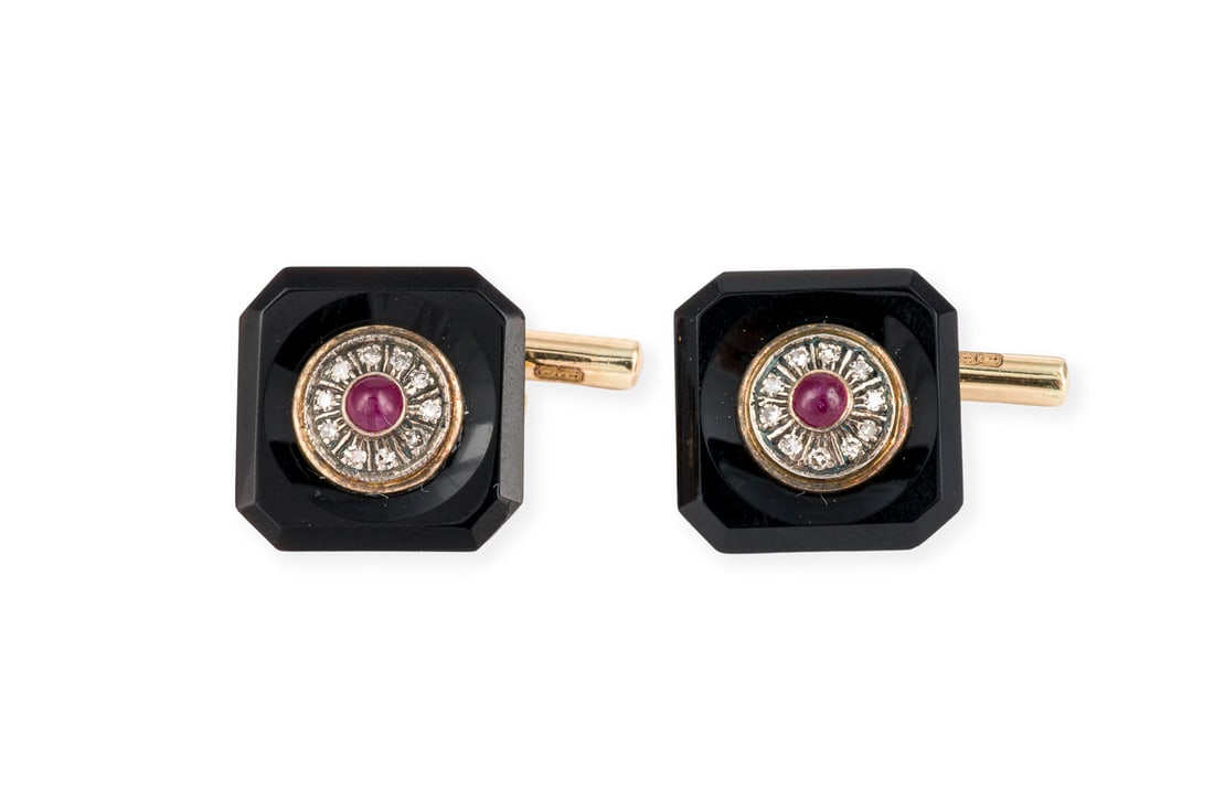 ONYX MANSCHETTEN KNOEPFE: ONYX MANSCHETTEN KNOEPFE AG/GG 750. Masse: ca. 14,1 x 14,1 mm. Ges.-Gew.: ca. 5,3 g. Manschettenknoepfe, besetzt mit je einem kleinen zentralen Rubin-Cabochon und einem Kranz aus Diamanten im