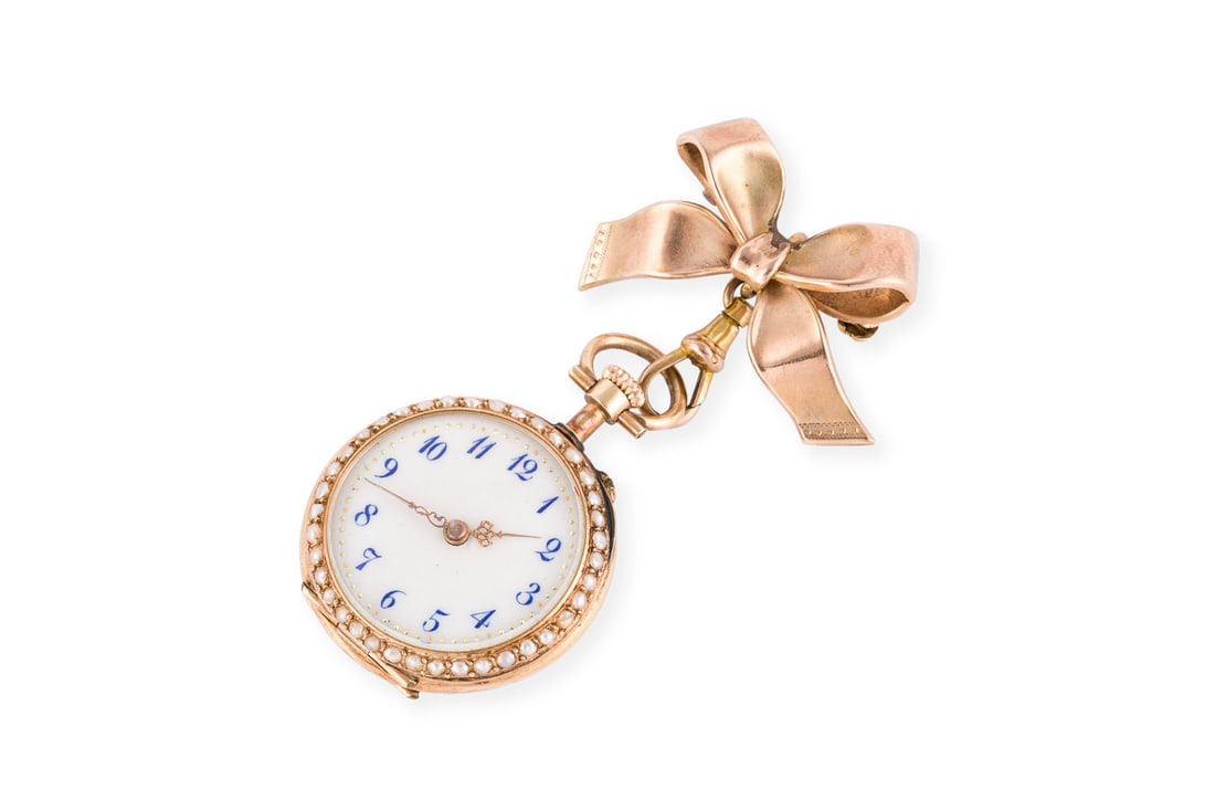 SCHMUCKVOLLE BROSCHEN-UHR: SCHMUCKVOLLE BROSCHEN-UHR Handaufzug (Nicht auf Funktion geprueft). RG 333/585. Masse: ca. 61,0 x 30,6 mm. Ges.-Gew.: ca. 18,9 g. Schleifenfoermige Brosche mit Schmuckvoller und emaillierter