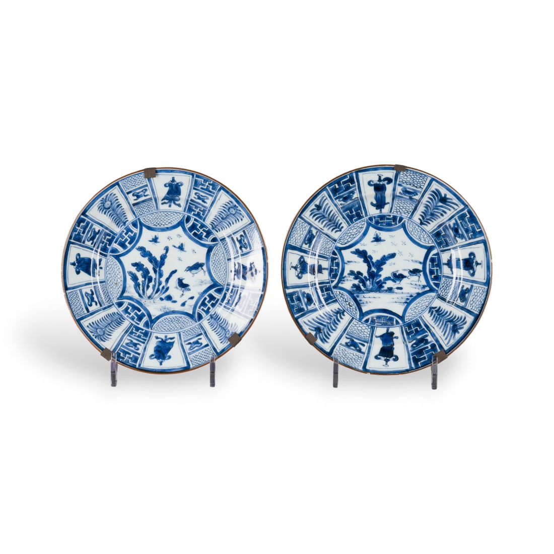EIN PAAR BLAU-WEISS 'KRAAK'-TELLER: A PAIR OF BLUE AND WHITE 'KRAAK' DISHES China, Qing dynasty Porcelain. D. 21 cm. Both with a artemisia leaf mark on the base. With traces of age and use, partially chipped to the rim; one with a hairl