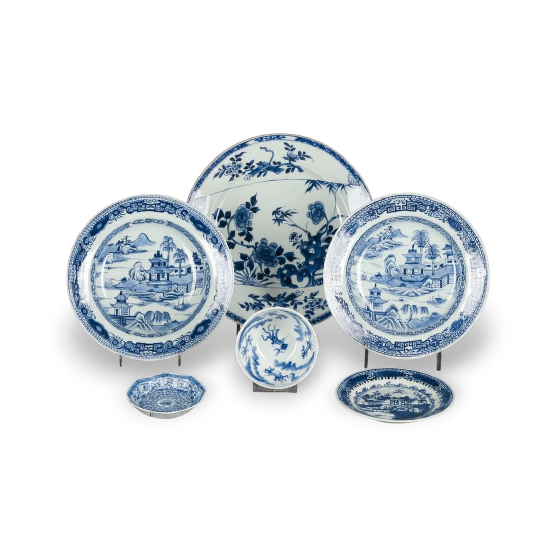 SECHS BLAU-WEISS PORZELLANOBJEKTE: SIX BLUE AND WHITE PORCELAIN OBJECTS China, Qing dynasty Porcelain. D. 10.8-27.7 cm. Including a bowl with a 'Kangxi nianzhi' mark on the base, two saucers and three dishes. With traces of age and use