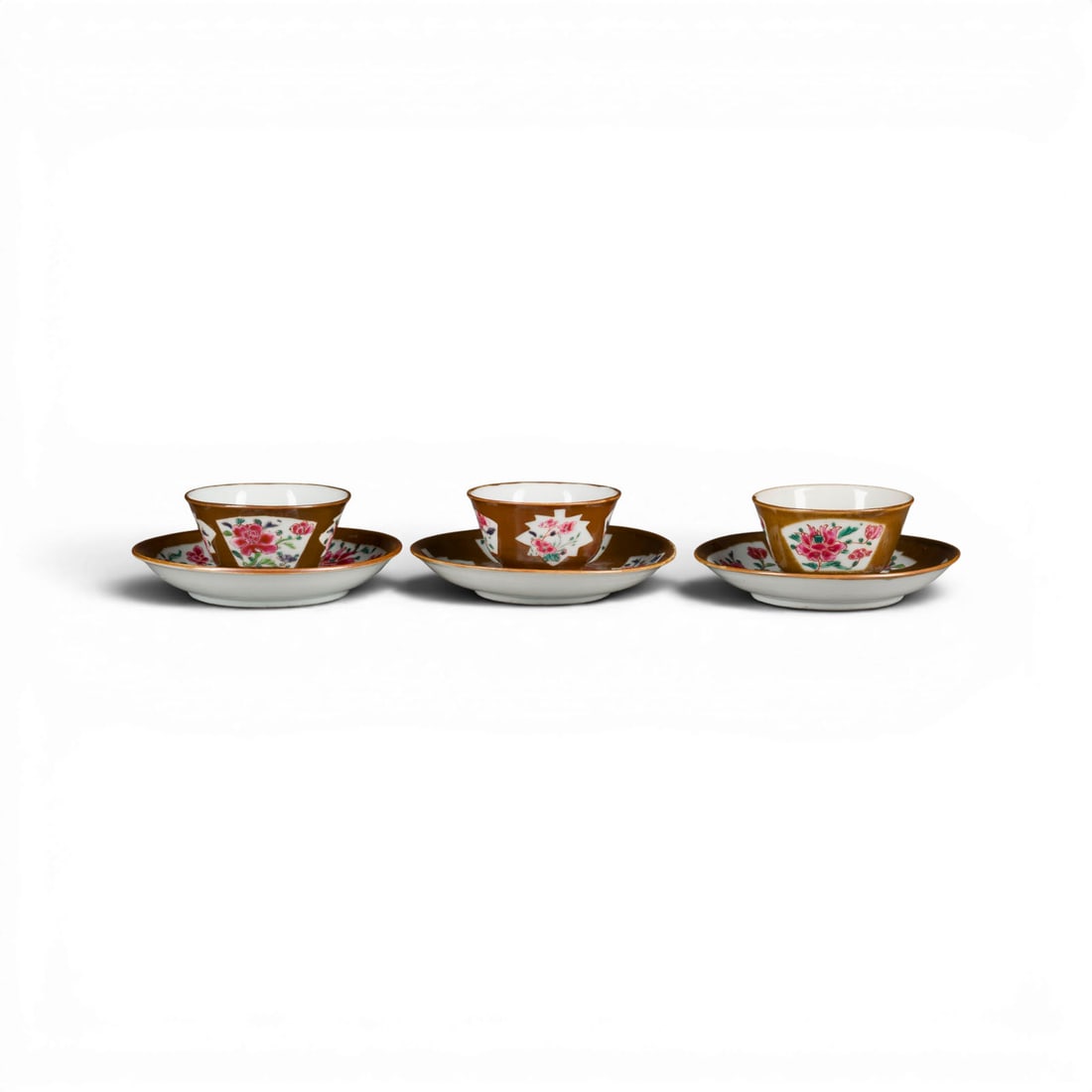 DREI PAARE CAFE-AU-LAIT-GLASIERTER FAMILLE-ROSE-TASSEN MIT UNTERTASSEN: THREE PAIRS OF CAFE-AU-LAIT-GLAZED FAMILLE ROSE CUPS AND SAUCERS China, Qing dynasty Porcelain. D. ca. 7 cm (cups), 12 cm (saucers). With traces of age and use.DREI PAARE CAFE-AU-LAIT-GLASIERTER FAMIL