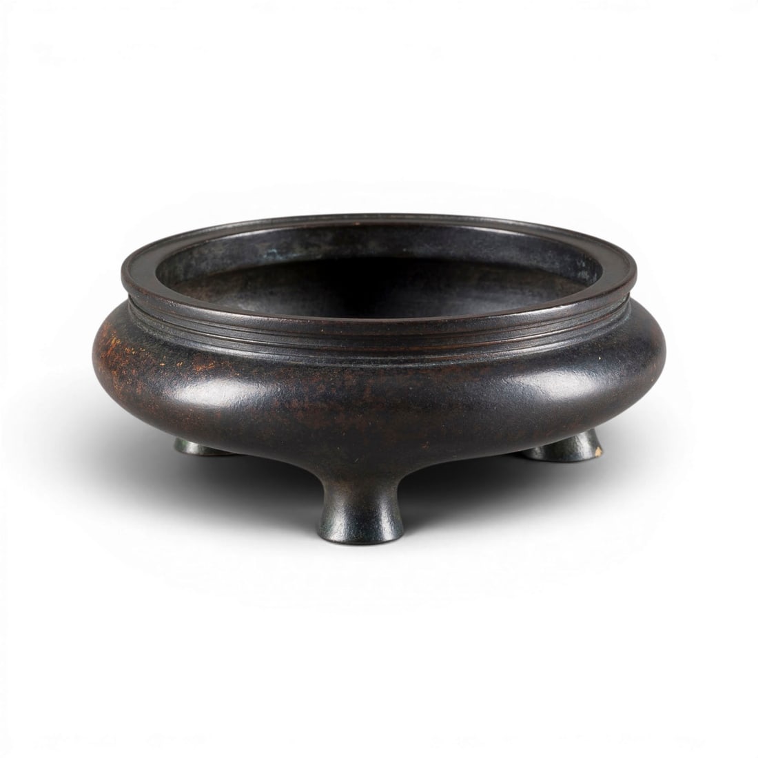 EIN DREIFUESSIGES RAEUCHERGEFAESS AUS BRONZE: A BRONZE TRIPOD INCENSE BURNER China Bronze. H. 6.3 cm, L. 17 cm. The incense burner bears a mark reading 'Xuande nianzhi' on the base. With traces of age and use, partially abraded.EIN DREIFUESSIGES 