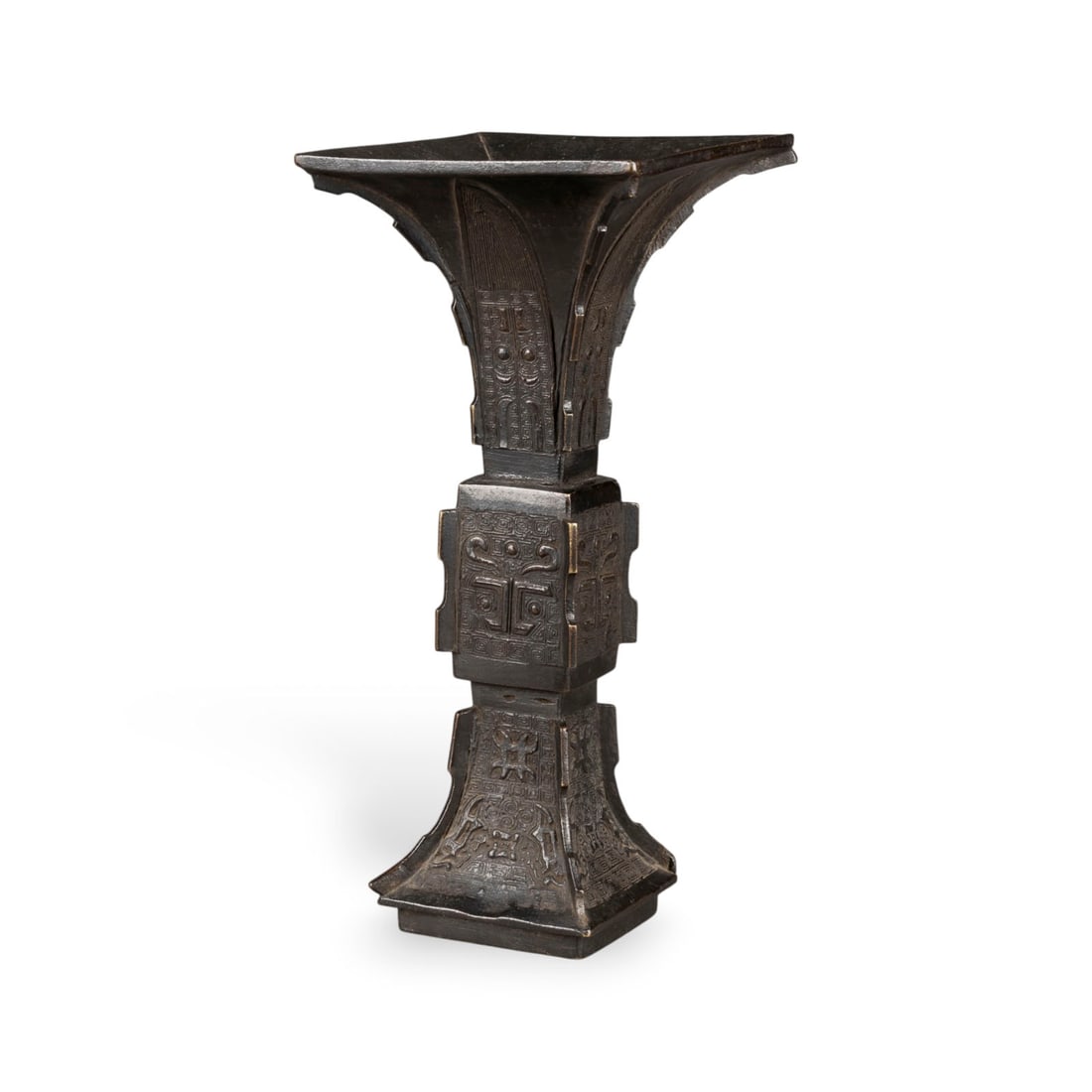 EINE ARCHAISIERENDE GU-FOERMIGE VASE AUS BRONZE: A BRONZE ARCHAISTIC GU-FORM VASE China, 18th century Bronze. H. 26.5 cm. With traces of age and use, partially abraded, the base covered with textile.EINE ARCHAISIERENDE GU-FOERMIGE VASE AUS BRONZE Ch