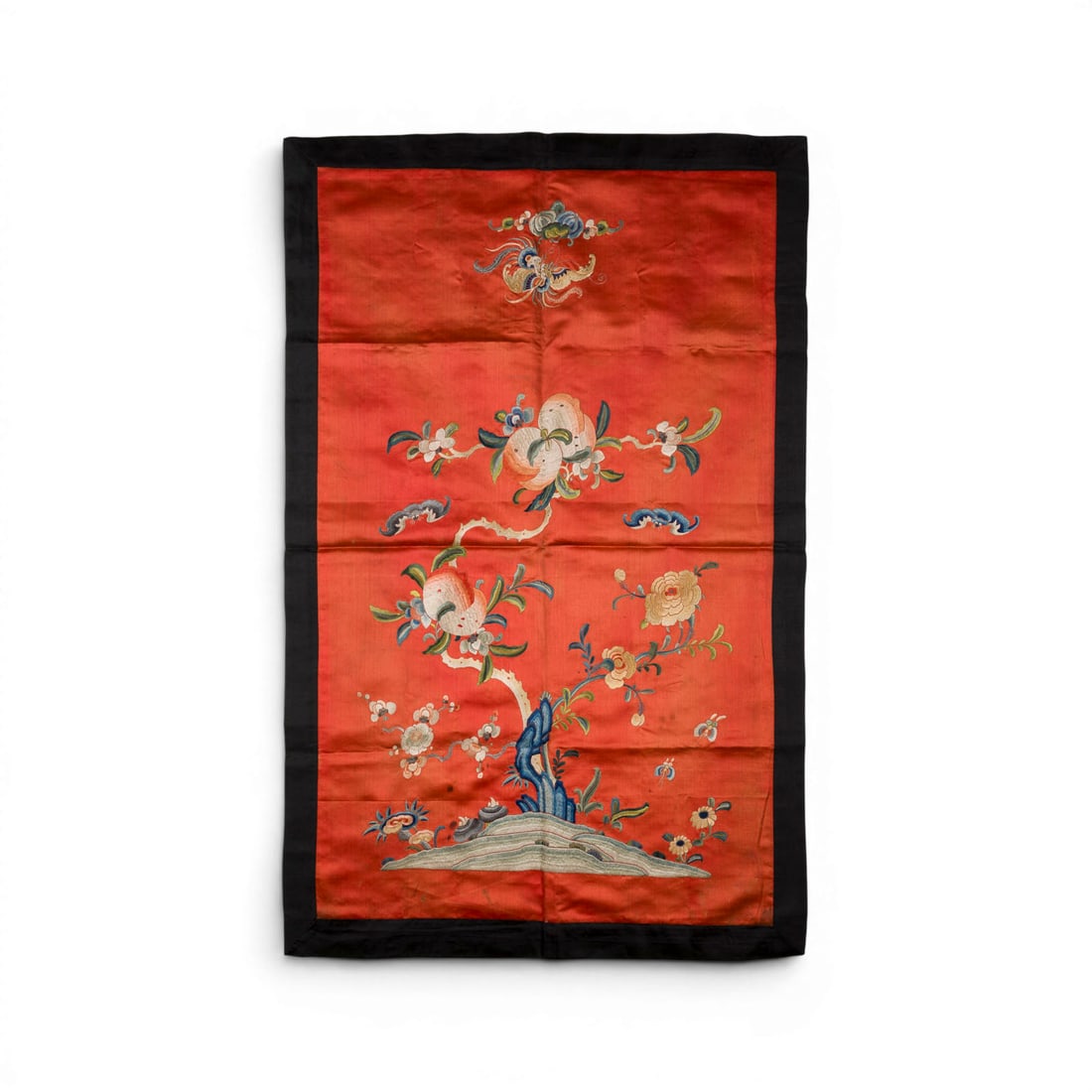 EIN BESTICKTER SEIDEN-WANDBEHANG: AN EMBROIDERED SILK WALL HANGING China, 19th century Embroidery. 94 x 60 cm. The wall hanging is decorated with peaches and bats. With traces of age and use, partially stained.EIN BESTICKTER