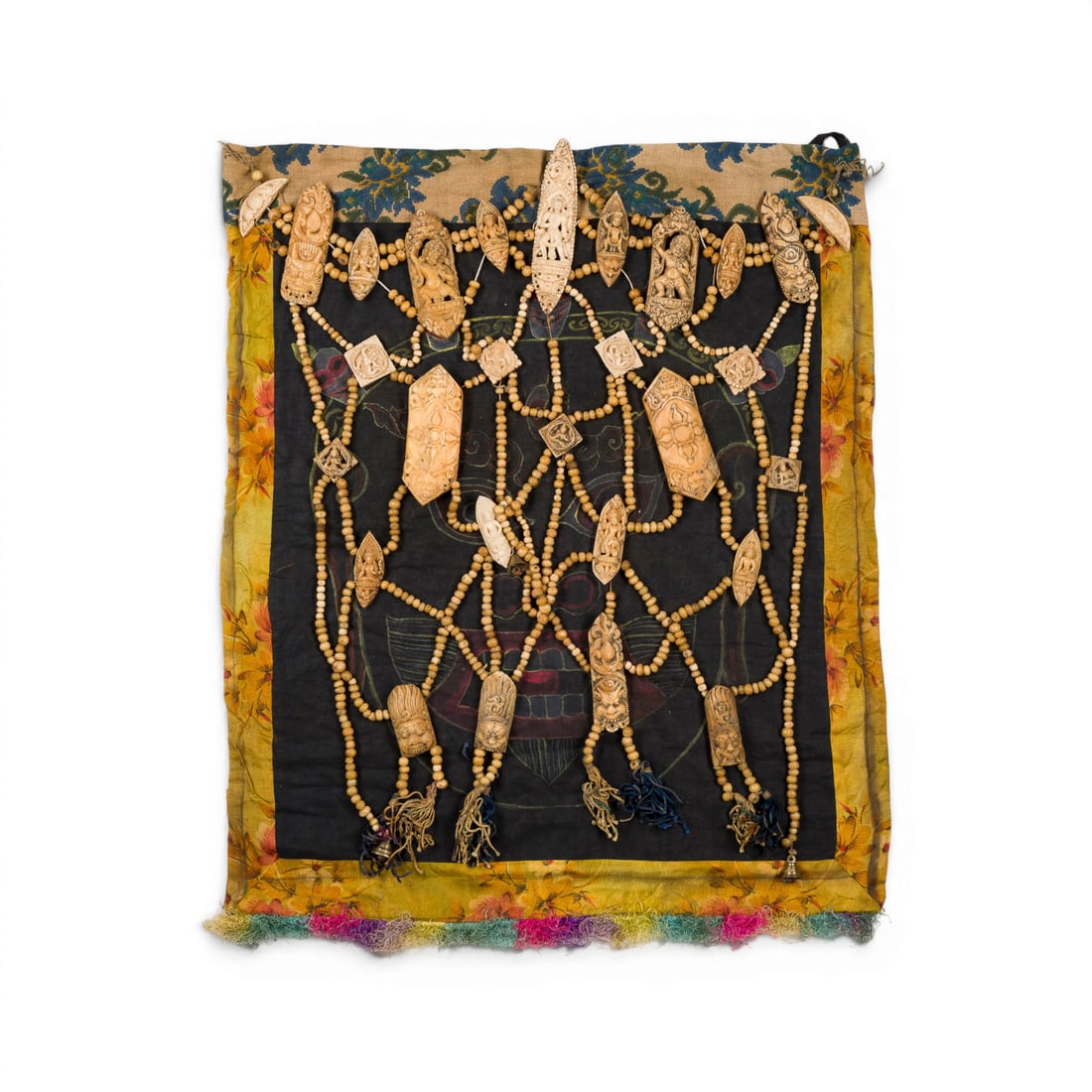 EINE KNOCHENSCHUERZE MIT DARSTELLUNG DES MAHAKALA AUF SCHWARZEM GRUND: A RITUAL BONE APRON China (Tibet), 19th century Bone/textile. 73 ? 56 cm. The apron is decorated with a depiction of Mahakala on a black ground. With traces of age.EINE KNOCHENSCHUERZE MIT DARSTELLUNG