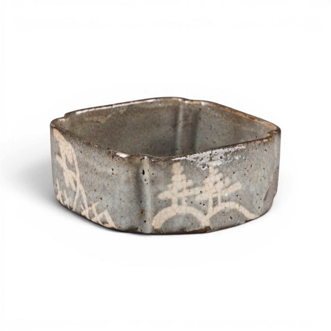 EINE KLEINE VIERSEITIGE NEZUMI-SHINO SCHALE: A SMALL FOUR-SIDED NEZUMI-SHINO BOWL Japan, late 16th/early 17th century Stoneware. H. 5.4 cm, W. 12 cm. The bowl is of a low, four-sided form with indented corners, set on a round, recessed foot.