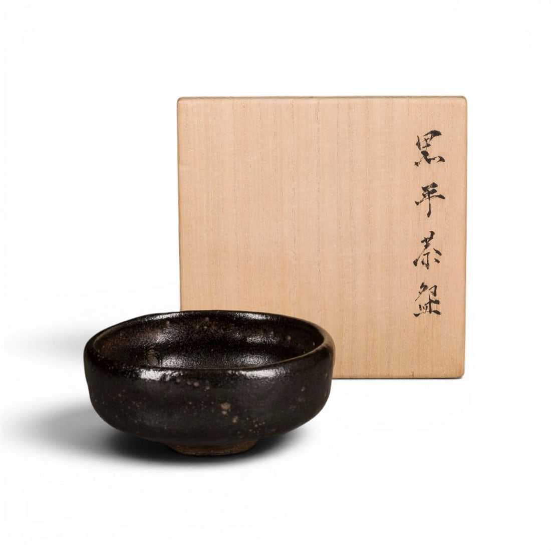 EIN KURO-RAKU SOMMER-CHAWAN (TEESCHALE): A KURO-RAKU SUMMER CHAWAN (TEA BOWL) Japan, 1st half of the 19th century Stoneware. H. 5.5 cm, D. 12 cm. The chawan, of baradai type, is of shallow form with vertical walls and a slightly constricted