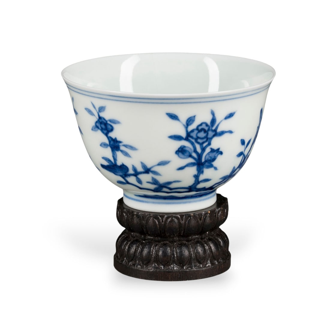 EINE KLEINE BLAU-WEISSE TASSE: A SMALL BLUE AND WHITE CUP China Porcelain. H. 5 cm. The cup is decorated with birds and flowers and bears a mark reading 'Da Ming Chenghua nianzhi' on the base. With traces of use and a hairline crac