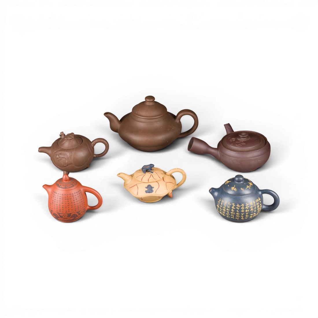 EIN KONVOLUT VON ZEHN CHINESISCHEN OBJEKTEN: A GROUP OF TEN CHINESE OBJECTS China Stoneware/soapstone/hardstone. H. 5-11 cm. Including six Yixing (zisha) pots, a pair of soapstone vases and a pair of hardstone Buddhist lions. With traces of use,
