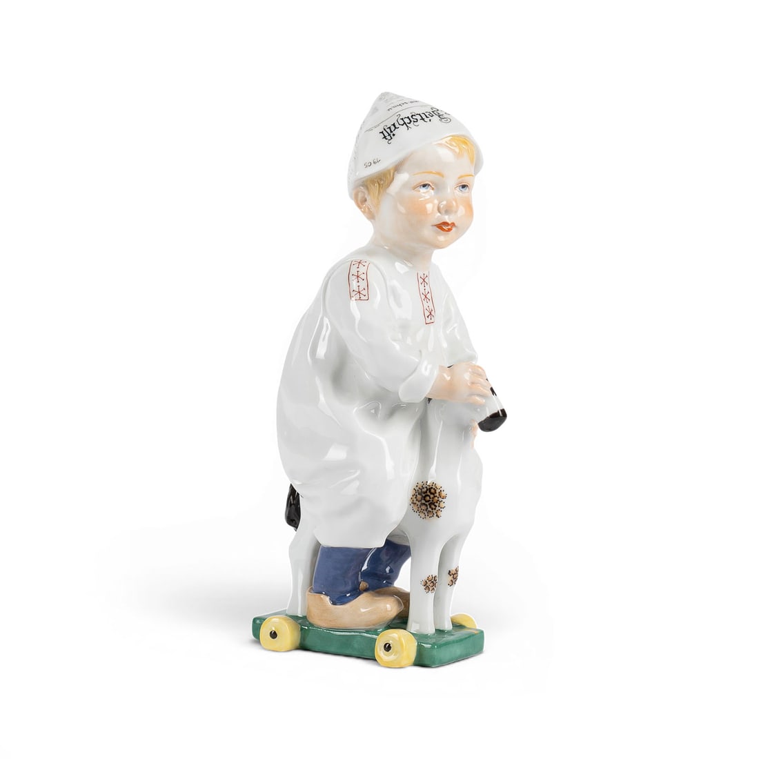 KONRAD HENTSCHEL | KIND, AUF EINEM HOLZPFERD REITEND: KONRAD HENTSCHEL 1872 Coelln - 1907 Meissen KIND, AUF EINEM HOLZPFERD REITEND Deutsch, Meissen, 1995 (Entwurf 1905) Porzellan, polychrom staffiert. H. 17,7 cm. Unterglasurblaue Schwertermarke, Press-