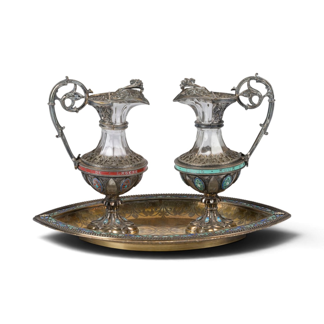 | POLLENGARNITUR: POLLENGARNITUR Frankreich, Paris, um 1890 Silber, vergoldet, Email, Glaskorpus. Ges.-Gew. 1222 g, H. 17,5 cm (Karaffen), L. 27 cm. Punziert mit Minervakopfmarke. Am Boden des Tabletts 'Offrande de