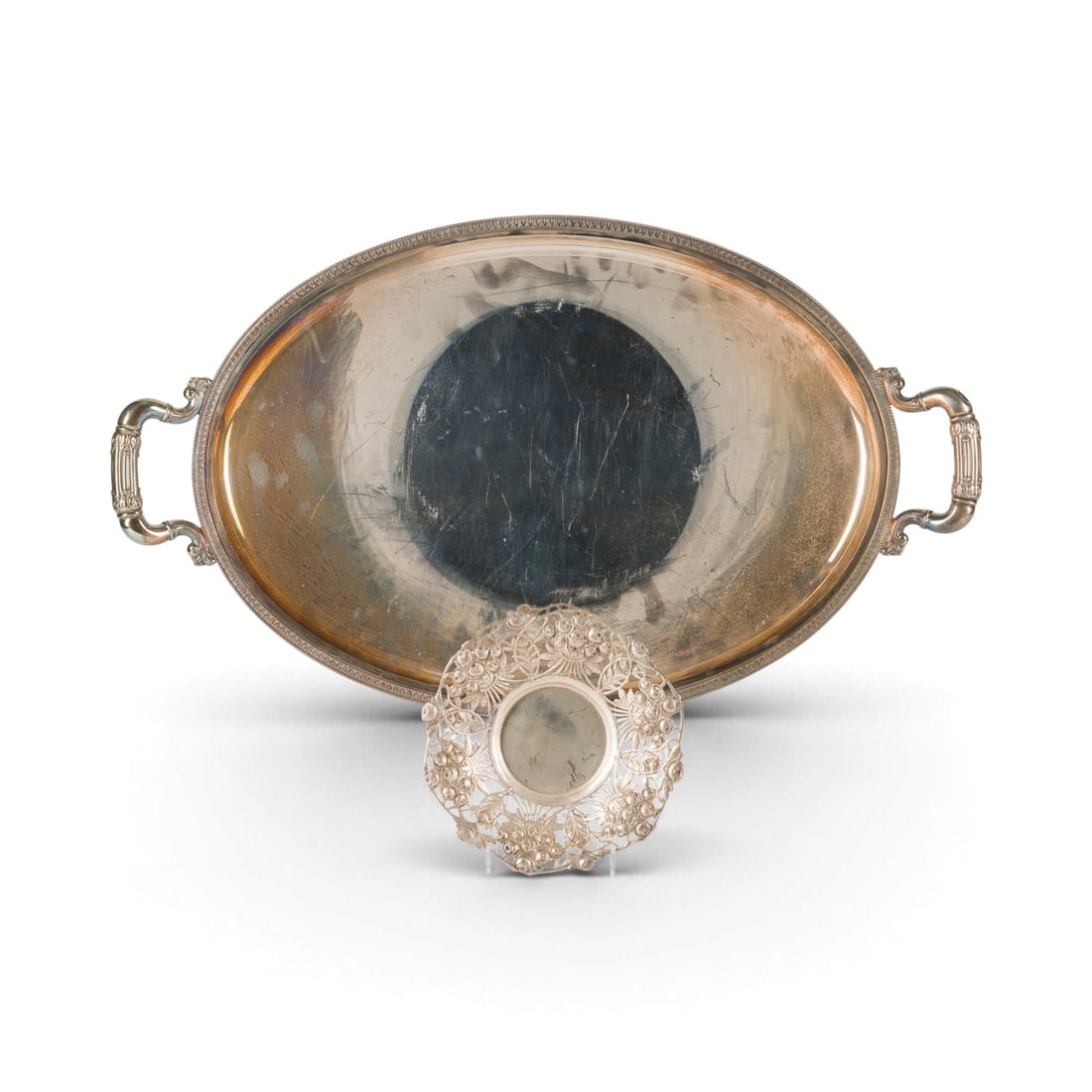 | HENKELTABLETT UND DURCHBRUCHSCHALE: HENKELTABLETT UND DURCHBRUCHSCHALE Wohl Deutsch, 20. Jh. 800/835er Silber. Ges.-Gew. 2148 g, L. 63 cm (Tablett), D. 17 cm (Sc. Punziert mit Herstellermarken (undeutlich), Feingehalt '800', '835'.