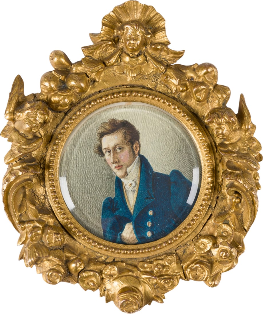 | BILDNIS EINES JUNGEN MANNES IN BLAUEM GEHROCK: PORTRAIT OF A YOUNG MAN IN A BLUE FROCK COAT France, c. 1800 Gouache on paper, under glass in a gilt metal frame. Diam. 8 cm (frame 17.5 x 15.5 x 2 cm). Minor rubbing, toning, and trimming.BILDNIS EIN