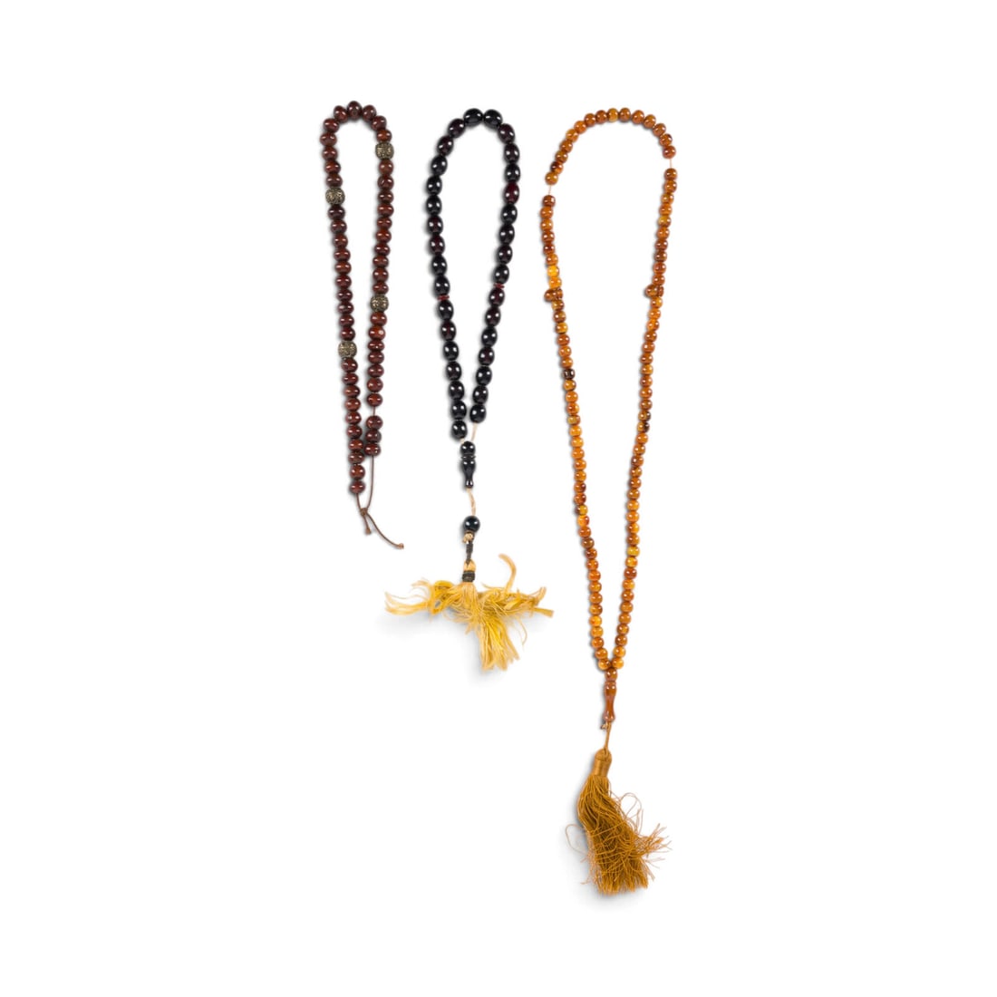 | DREI GEBETSKETTEN: THREE PRAYER BEADS 19th/20th century Wood, amber, metal, and other materials. Lengths approx. 55, 38, and 26 cm. Partially damaged.DREI GEBETSKETTEN 19./20. Jh. Holz, Bernstein, Metall und andere