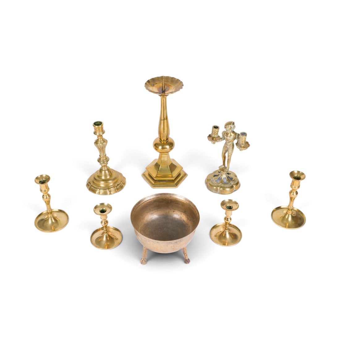 | KONVOLUT AUS 7 LEUCHTERN UND EINEM GRAPEN: GROUP OF 7 CANDLESTICKS AND A TRIPOD CAULDRON 18th-19th century Brass and bronze. Max. height 36 cm, min. height 11 cm; cauldron 13.5 x 18 x 18 cm. Signs of use, some damage.KONVOLUT AUS 7 LEUCHTERN U