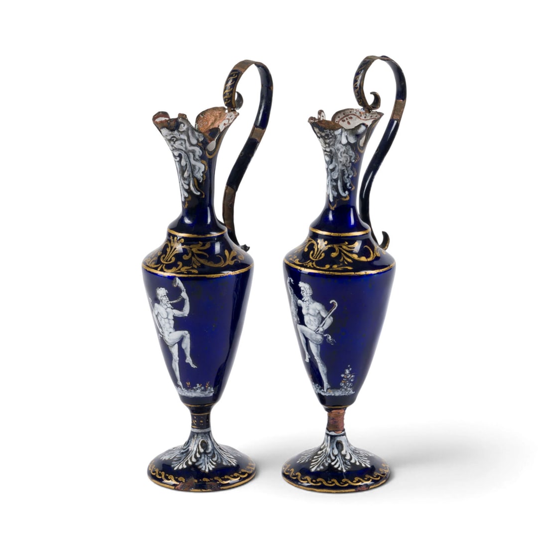 | ZWEI FRANZOeSISCHE EMAILLE-ZIERKANNEN: TWO FRENCH ENAMEL DECORATIVE PITCHERS France, 19th century Cobalt blue enamel on a copper body, heightened with opaque white enamel and in gold. Approx. 18.5 x 7 x 5 cm. One marked beneath the base
