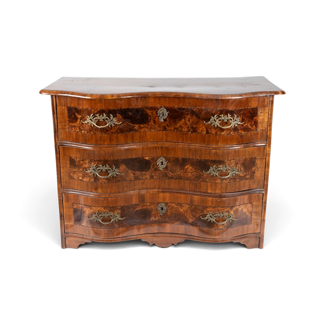 | FRAeNKISCHE BAROCK KOMMODE: FRAeNKISCHE BAROCK KOMMODE Wuerzburg / Mainfranken, um 1750 Nussbaum, Nusswurzel, Edelhoelzer, furniert. H. 84, B. 119, T. 59 cm. Dreischuebige Barockkommode mit mehrfach geschweifter Front und