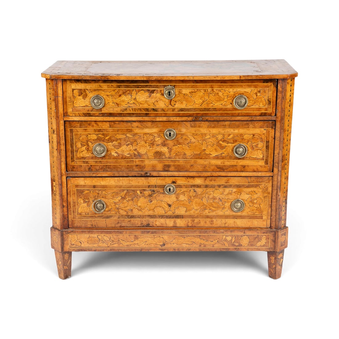 | KLASSIZISTISCHE KOMMODE: KLASSIZISTISCHE KOMMODE Oesterreich, um 1780-1800 Nussbaum, Ahorn, Zwetschge und verschiedene Edel- und Obsthoelzer, furniert und reich intarsiert, Messingeschlaege. H. 84, B 96, T. 42 cm.
