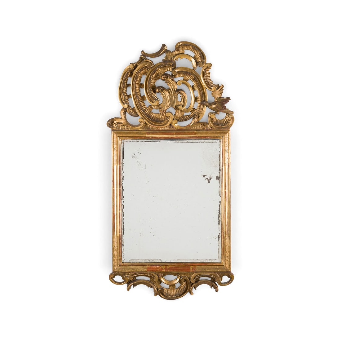| PRACHTVOLLER ROKOKO WANDSPIEGEL: MAGNIFICENT ROCOCO WALL MIRROR Probably Italy, presumably Florence or Lucca, circa 1750-1780 Wood, poliment gilding, mirror glass. H. 92, W. 44, D. 5 cm. Tall rectangular gold leaf frame with dynamic,