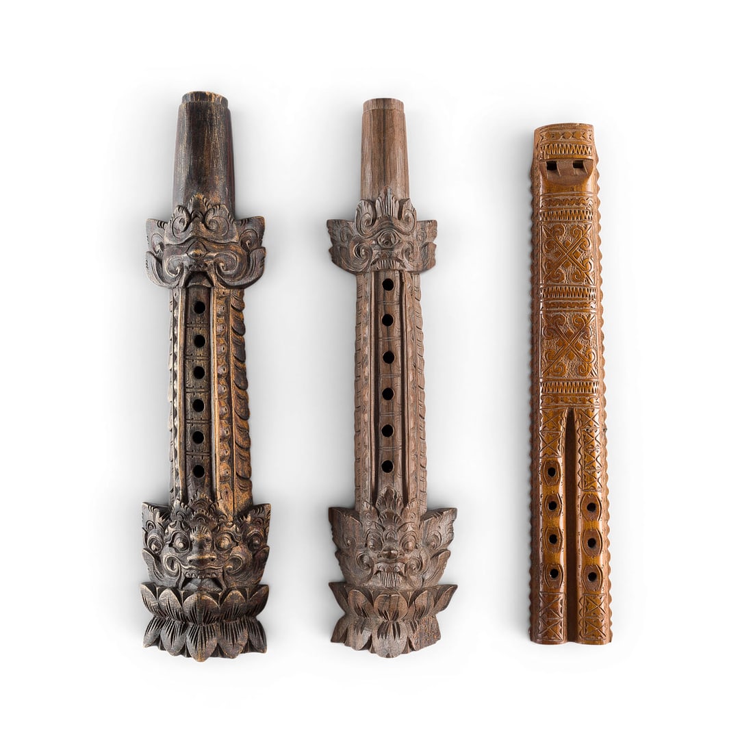 | KONVOLUT VON DREI FLOeTEN: GROUP OF THREE FLUTES Indonesia and the Balkans, 20th century Hand-held flutes, dark brown wood, some featuring floral carved decoration on both sides. Lengths: 32, 33.5, and 34 cm. Comprising a