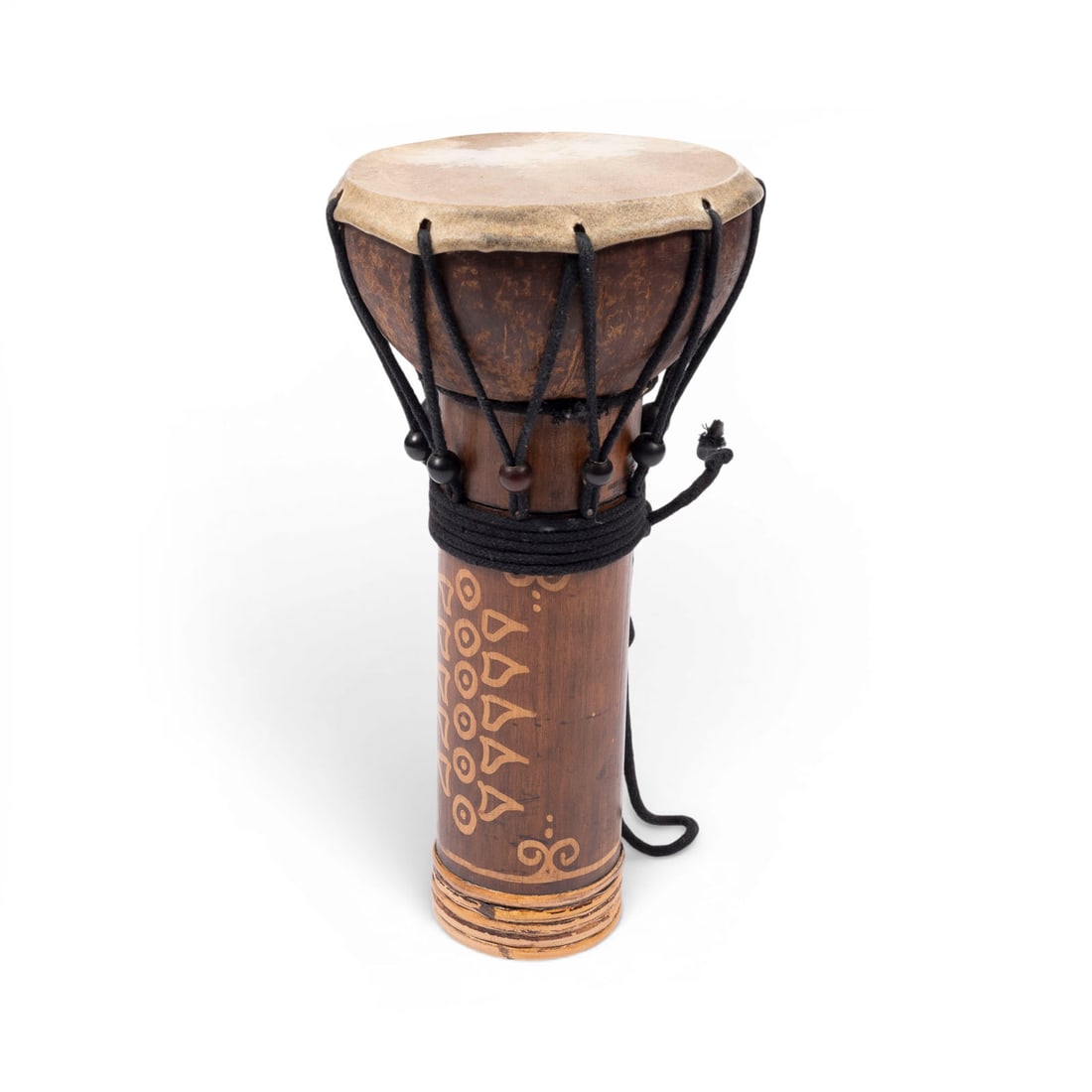 | DJEMBE (HANDTROMMEL): DJEMBE (HAND DRUM) West Africa, 20th century Wood, cup-shaped, ornamented body, covered with animal skin, traditional rope tensioning. H. 30, D. 14.5 cm, Wt. 0.5 kg. Signs of use and play; rubbed and