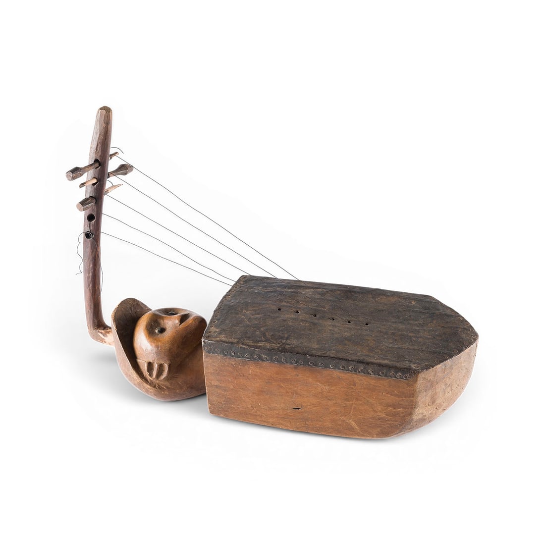 | FIGUeRLICHE BOGENHARFE (VERMUTLICH KUNDI ODER NGOMBI): FIGURAL ARCHED HARP (PROBABLY KUNDI OR NGOMBI) Congo (formerly Zaire), Africa, 20th century. Pentagonal wooden resonator, nailed animal-skin covering, carved neck base featuring a human head, curved
