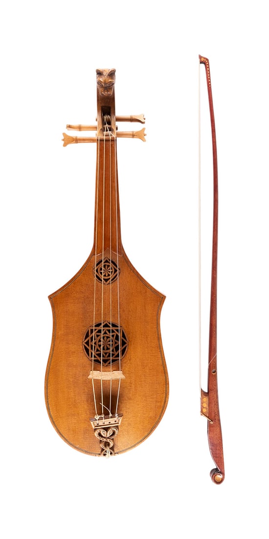 | HISTORISIERENDE CITOLE UND BOGEN: HISTORICIZING CITOLE AND BOW Nidderau, 20th century Spruce top with two openwork carved wooden rosettes, carved animal head at the end, four strings. Length approx. 53 cm. Inside: workshop label