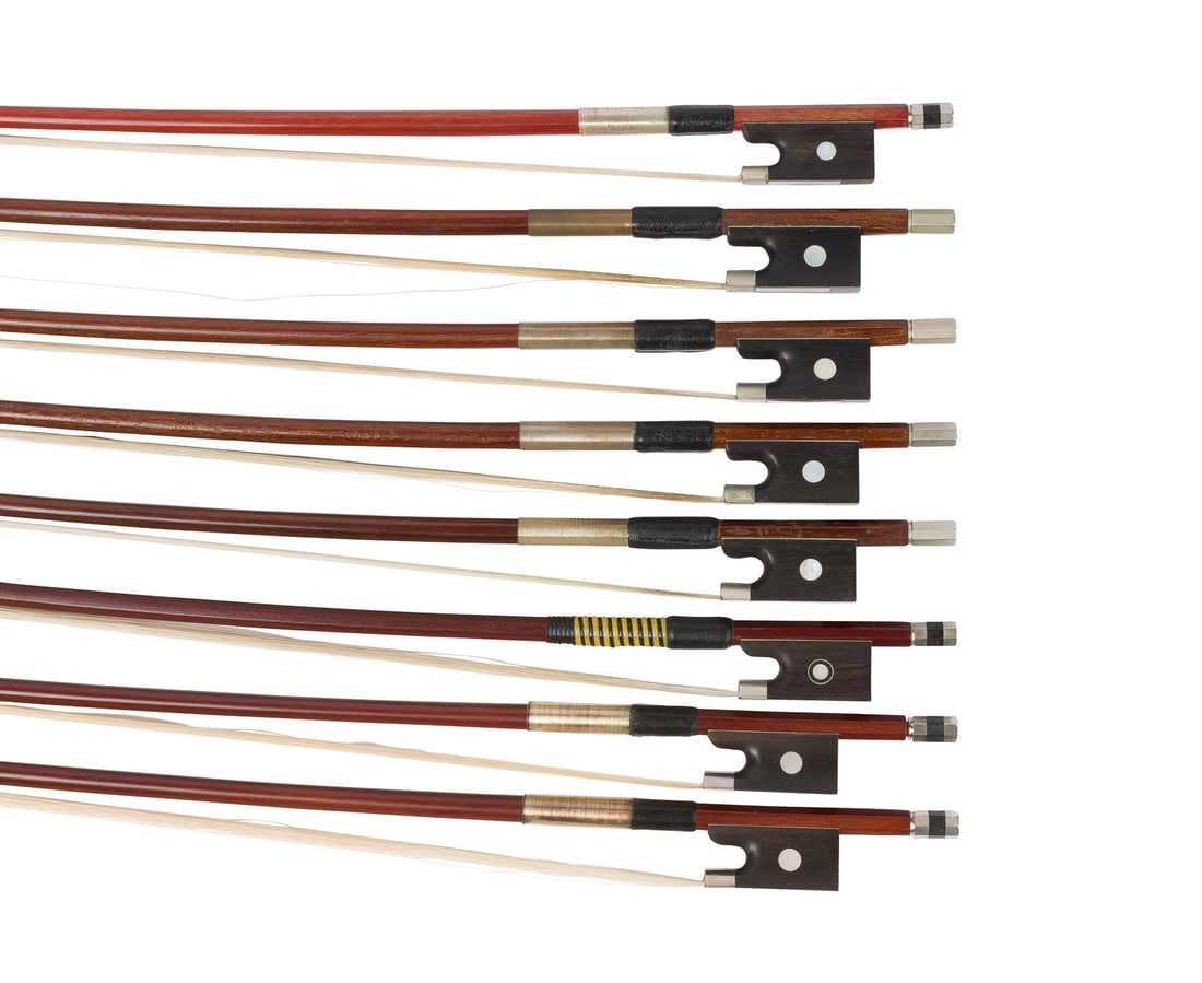 | KONVOLUT VON ACHT SCHUeLER VIOLINBOeGEN (1/4, 1/2, 3/4): GROUP OF EIGHT STUDENT VIOLIN BOWS (1/4, 1/2 AND 3/4) 20th century. Round and octagonal sticks, single and Parisian eyes, winding, thumb leather, bone, Bakelite and synthetic head plates. Lengths