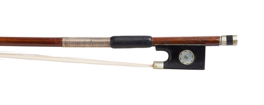| VIOLINBOGEN 'DODD': VIOLIN BOW 'DODD' Probably England, early 20th century. Round shaft, small flower-shaped eye, nickel silver mountings, winding, thumb leather, ivory frog. Length: 73.9 cm, weight: approx. 56 g. Violin