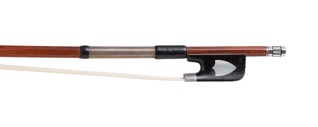 | VIOLINBOGEN GEMARKT 'ARNOLD VOIGT' (WOHL MAX PENZEL): VIOLIN BOW MARKED 'ARNOLD VOIGT' (PROBABLY MAX PENZEL) Markneukirchen, circa 1910/1920 Round Pernambuco stick, decorative label on the frog, silver mountings, thumb leather, winding, ivory end plate. 