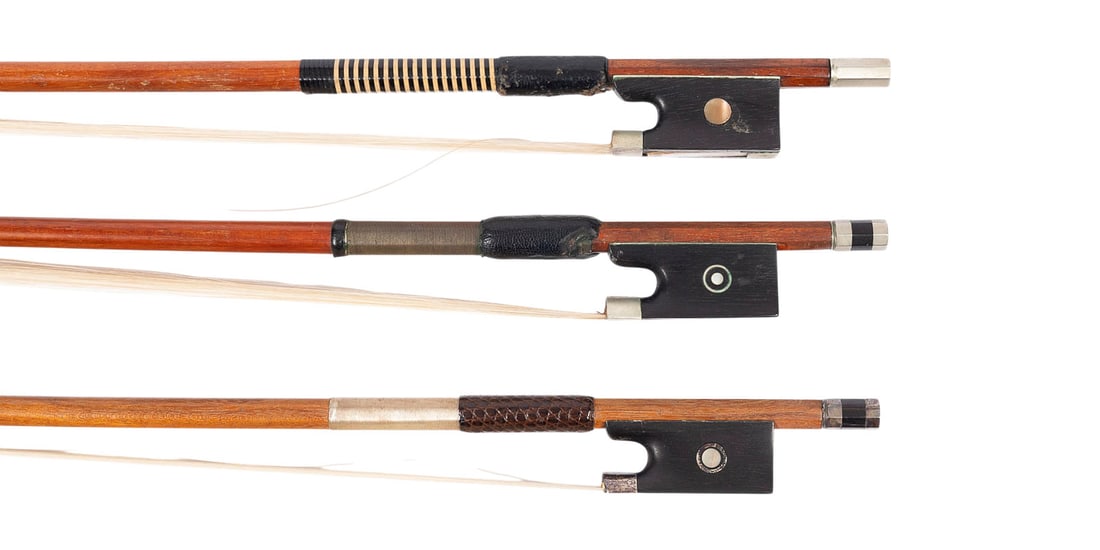 | KONVOLUT VON DREI VIOLINBOeGEN 'BALSEREIT': GROUP OF THREE VIOLIN BOWS BY 'BALSEREIT' German, 20th century Each with a round stick; features include Parisian and simple eyes, winding, thumb leather, and bone and synthetic headplates. Lengths: 7
