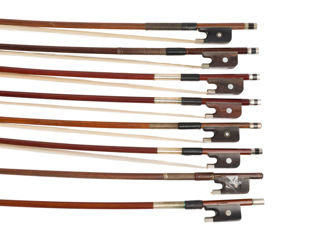 | KONVOLUT VON ACHT CELLOBOeGEN: GROUP OF EIGHT CELLO BOWS 20th century. Round and octagonal sticks, single and Parisian eyes, winding, thumb leather, bone and synthetic head plates. Lengths 70 to 72 cm, including one 1/2-size bow me