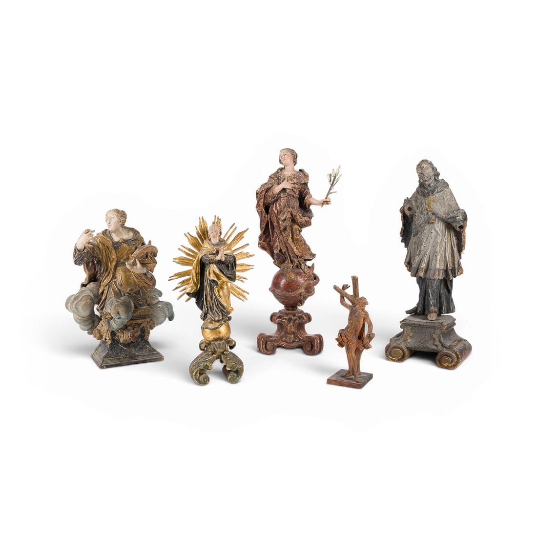 | KONVOLUT VON FUeNF SAKRALEN FIGUREN: GROUP OF FIVE SACRED FIGURES South German, 18th century Linden wood, carved in the round, polychromed and gilded, backs flattened. Heights 18 to 37 cm. Maria Immaculata within a radiant halo: The Virg