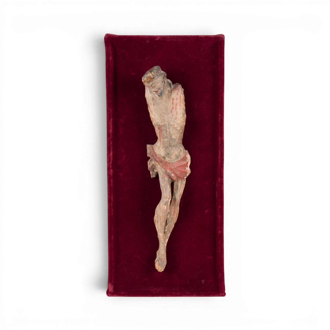 | KORPUS CHRISTI: CORPUS CHRISTI South German, 18th century Wood, carved in the round, gessoed and polychromed; mounted on a red velvet panel (16.5 x 37 cm). Figure height 29 cm, width 7 cm. Fragmentary figure of Chris