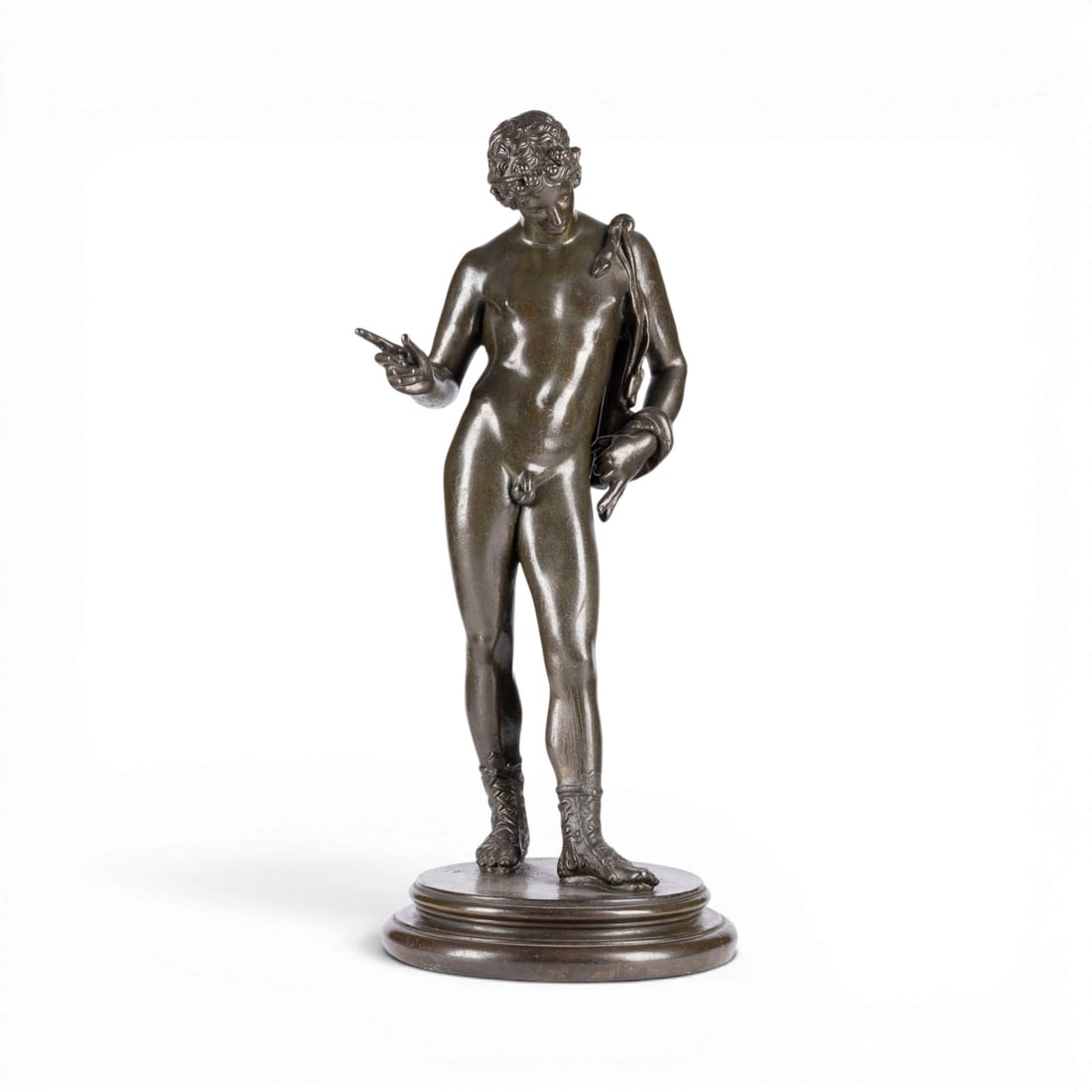 ITALIENISCHER BILDPLASTIKER | NARZISS VON POMPEJI (DIONYSOS): ITALIAN SCULPTOR Active 20th century NARCISSUS OF POMPEII (DIONYSUS) Electrotype cast, dark patina, on a round plinth. Total height 69 cm, diameter 28 cm. Areas of rubbing and loss of patina.ITALIENIS
