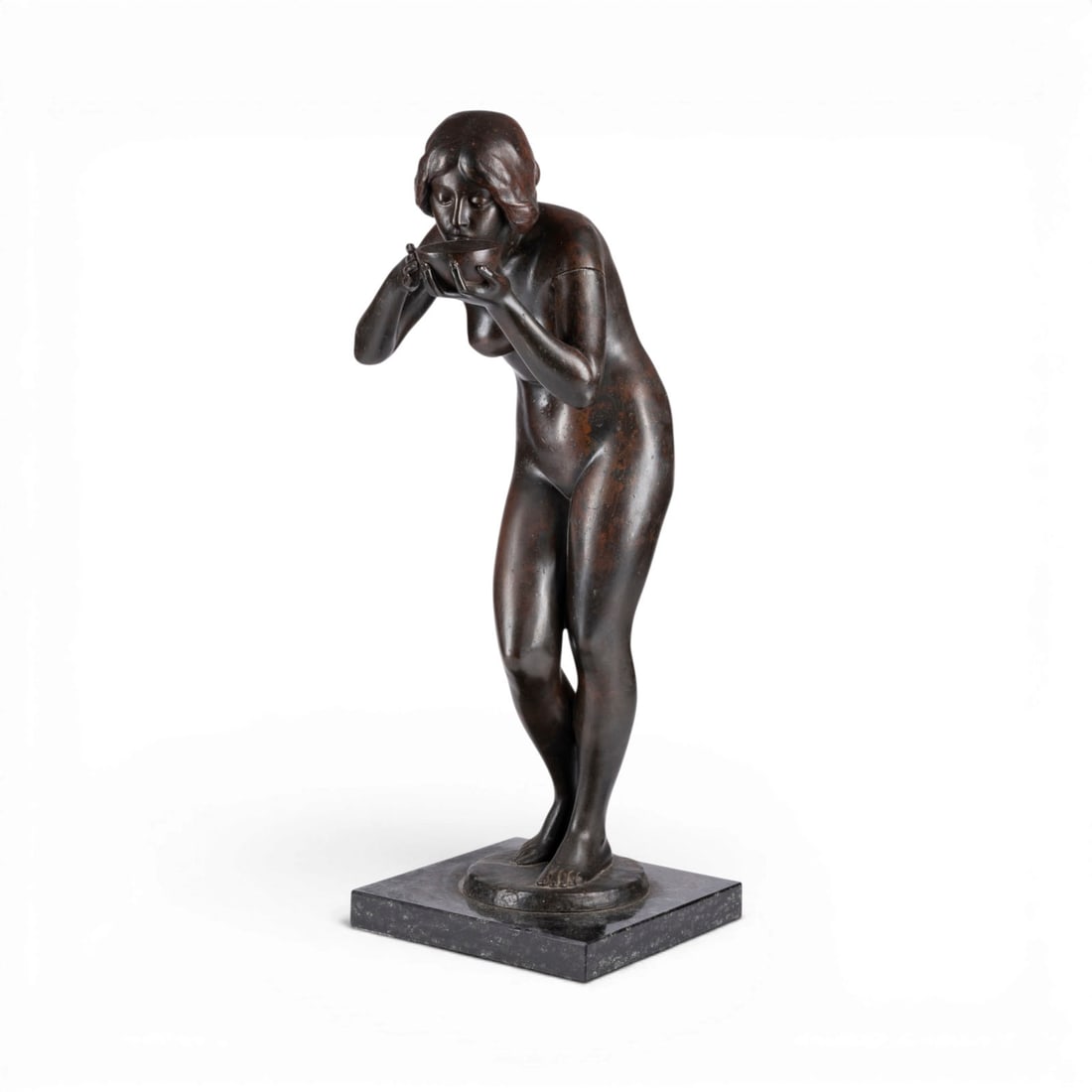 VICTOR HEINRICH SEIFERT | DIE TRINKENDE: VICTOR HEINRICH SEIFERT 1870 Vienna - 1953 Berlin THE DRINKING WOMAN Bronze, dark patina, on a round plinth and square marble base (H. 3 cm). H. 66, W. 28, D. 26 cm. Signed 'Seifert' on the plinth. Mi
