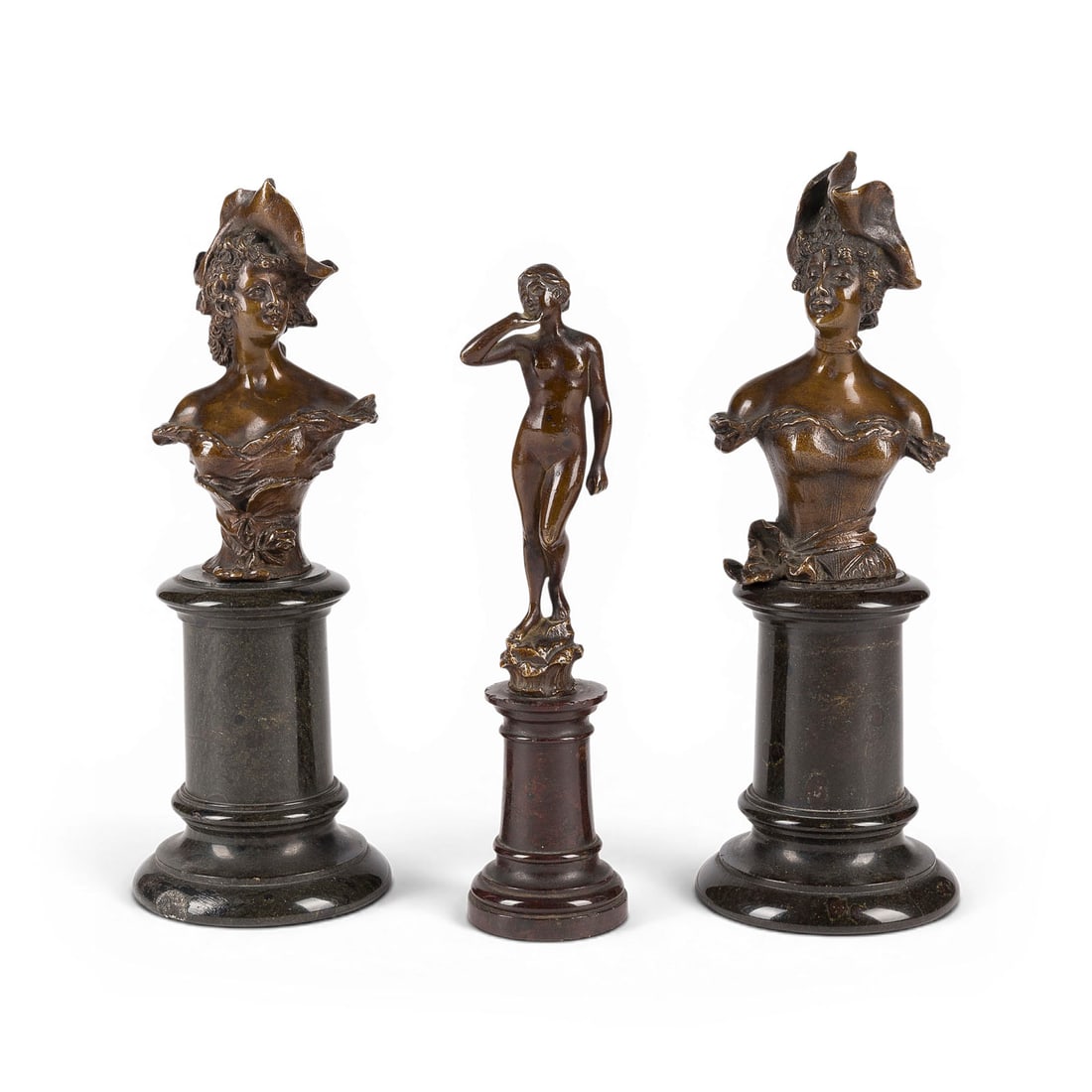 FRANZ IFFLAND | KONVOLUT VON DREI BRONZEFIGUREN: ZWEI DAMENBUeSTEN UND EIN FRAUENAKT: FRANZ IFFLAND 1862 Berlin - 1935 Berlin GROUP OF THREE BRONZE FIGURES: TWO BUSTS OF LADIES AND A FEMALE NUDE Bronze, brown patina, each mounted on a marble column. Total height 16/18/19 cm. Two