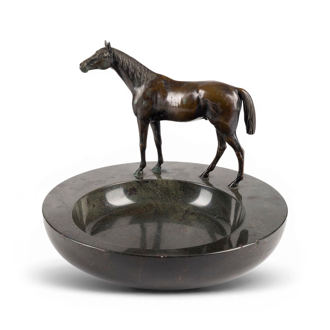 UNBEKANNTER BILDPLASTIKER | ZIERSCHALE MIT PFERD: UNKNOWN SCULPTOR Active early 20th century DECORATIVE BOWL WITH HORSE Bronze, dark patina, on a round natural stone base. H. 18 cm, D. 30 cm, weight 7.7 kg. Round, shallow bowl-suitable for serving,