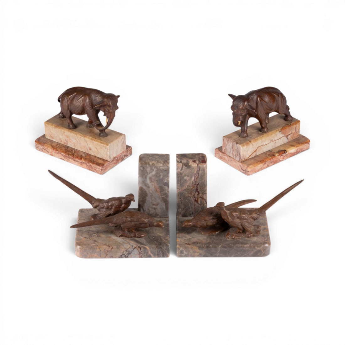 UNBEKANNTER BILDPLASTIKER | PAAR ELEFANTEN UND FASANE ALS BUCHSTUeTZEN: UNKNOWN SCULPTOR Active early 20th century PAIR OF ELEPHANTS AND PHEASANTS AS BOOKENDS Bronze, dark brown patina, each on a marble base; tusks carved from bone. H. 13.5/12, W. 16/20, D. 8.5/11 cm. Uns